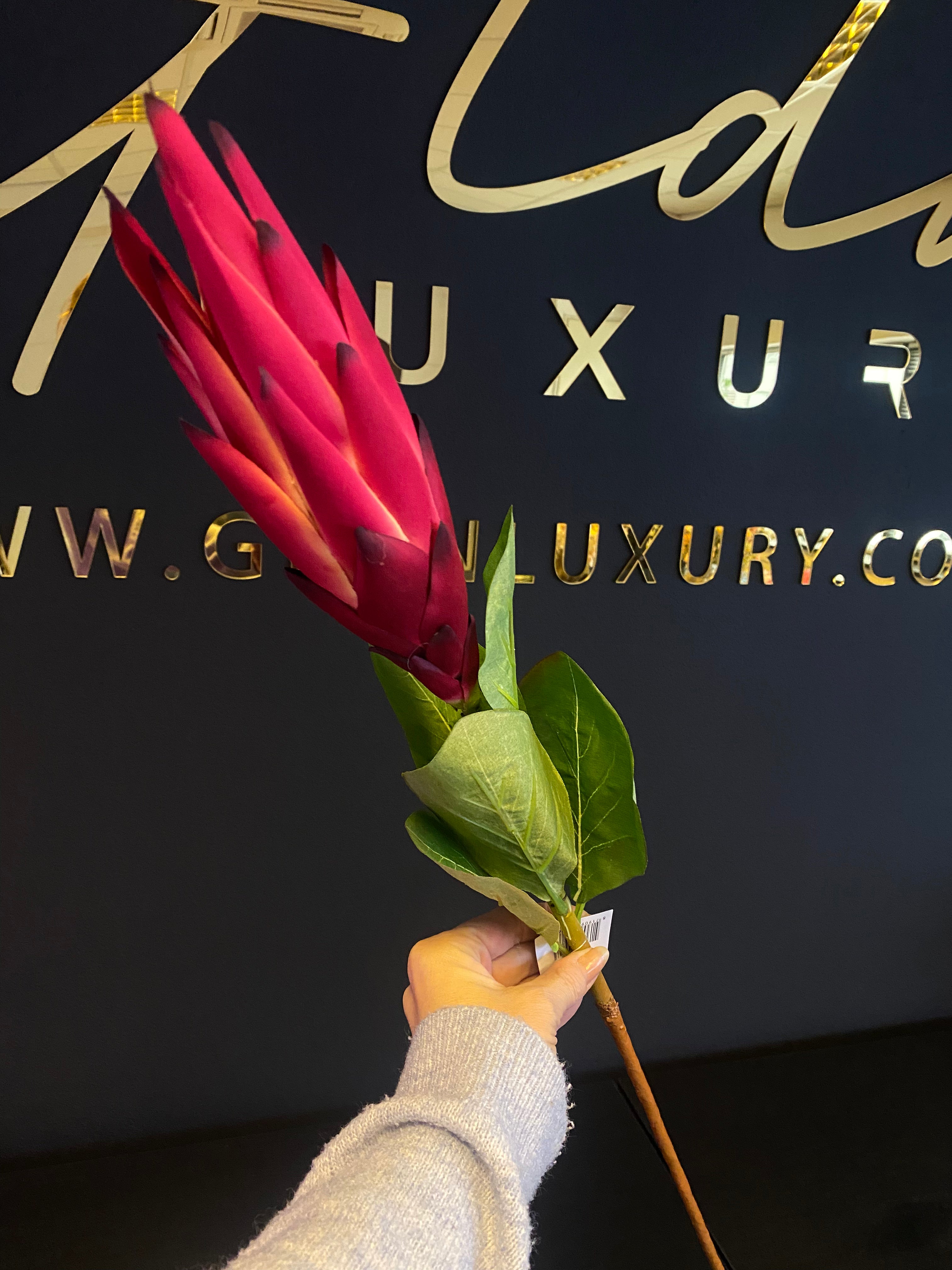 Fuchsia tropische kunstbloem van 90 cm met langwerpige fuchsiaroze bloemblaadjes, groene bladeren en een lange steel.